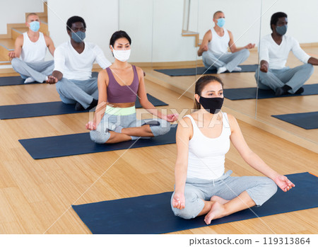 Young people meditating together at yoga class Young people meditating together at yoga class 119313864
