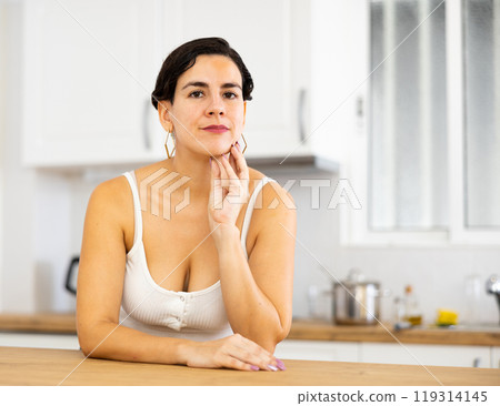 Portrait of girl housewife standing at home kitchen 119314145