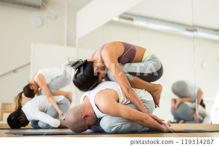 Couples practicing yoga with partner at studio 119314287