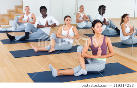 Adult people exercising during yoga class in fitness center 119314288