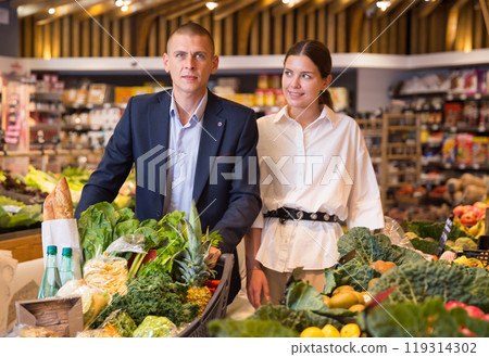 Couple shopping at vegetables department at supermarket 119314302