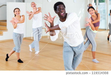 Young adult man exercising at dance class Young adult man exercising at dance class 119314308