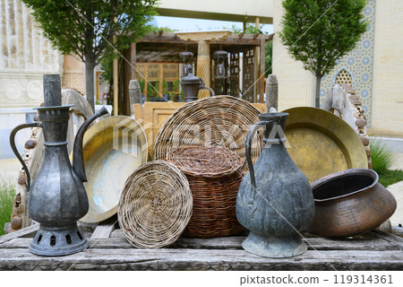 Traditional Uzbek metal jugs, plates, pot and wicker baskets in Samarkand, Uzbekistan 119314361
