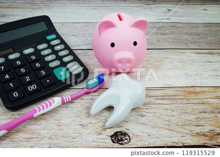 Toothbrush dental hygiene concept with calculator and piggy saving on wooden background, Dental money and dentist treatment costs 119315529