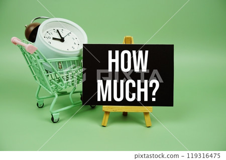 How Much? text message on paper card with alarm clcok and trolley shopping cart on green background 119316475