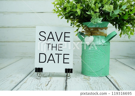 Save The Date text on paper card with artificial plant on Save The Date text on paper card with artificial plant on 119316695