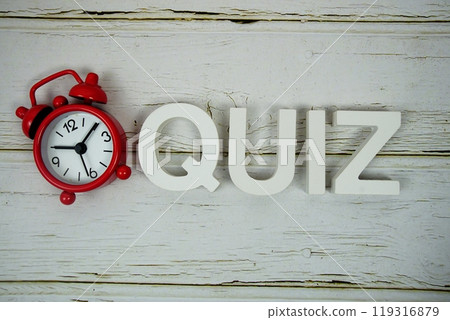 Quiz alphabet letters with alarm clock top view on wooden 119316879