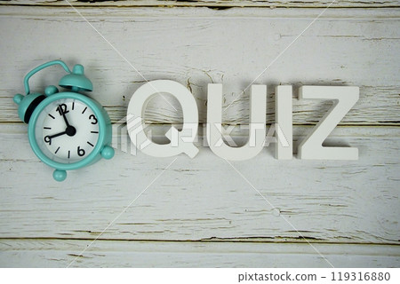 Quiz alphabet letters with alarm clock top view on wooden 119316880