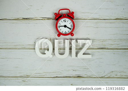 Quiz alphabet letters with alarm clock top view on wooden 119316882
