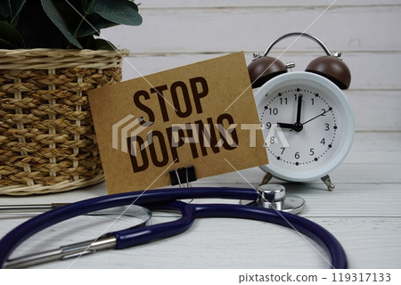 Stop Doping text message on paper card with stethoscope and alarm clock on wooden background 119317133
