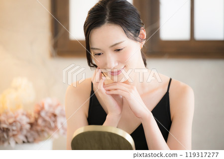 A woman uses yellow light to care for her skin before going to bed A woman uses yellow light to care for her skin before going to bed 119317277