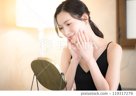 一位女士在睡前在黃色筒燈下護理皮膚 119317279