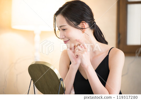 A woman taking care of her skin before going to bed with yellow downlights 119317280