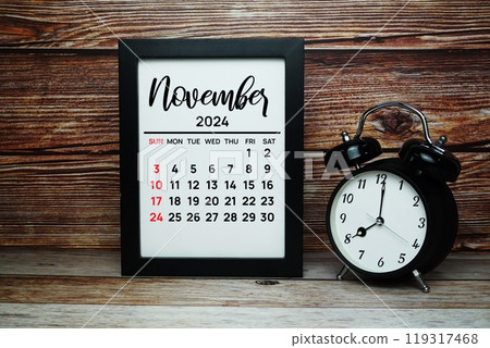 NOVEMBER 2024 monthly calendar for planning and management concept with alarm clock on wooden background 119317468