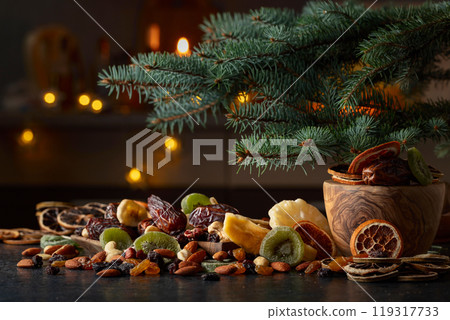 Dried tropical fruits and Christmas tree on a kitchen table. Dried tropical fruits and Christmas tree on a kitchen table. 119317733