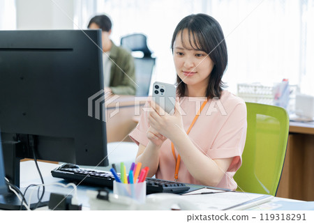 有一部智能手機的女商人在辦公室 119318291