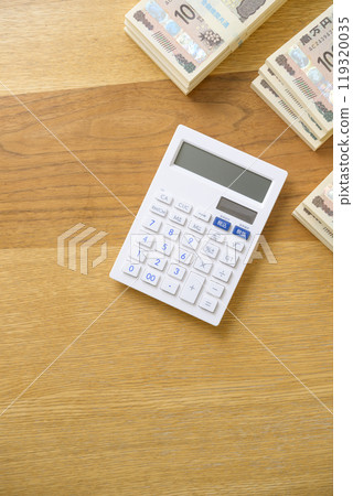 A stack of bills and a calculator on a desk (new bill version) 119320035