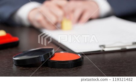 The hands of a businessman stamping a contract The hands of a businessman stamping a contract 119321482