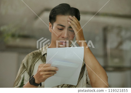 Worried Young Man Reading Letter 119321855