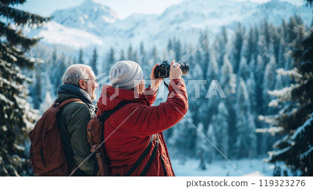Two photographers hiking in snowy mountains are taking pictures of the landscape 119323276