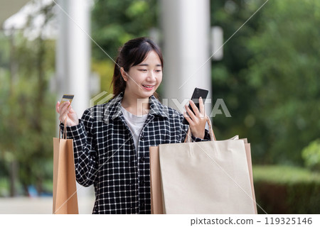 Black Friday Shopper Excitedly Using Mobile for Seamless Shopping Experience 119325146