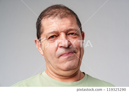 Middle-aged man with a thoughtful expression against a plain background Middle-aged man with a thoughtful expression against a plain background 119325290