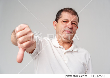 A middle-aged man expressing disapproval with a thumbs-down gesture i 119325319