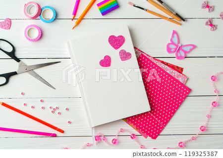 Crafting a colorful workspace with decorations, stationery, and artistic tools on a clean wooden surface 119325387