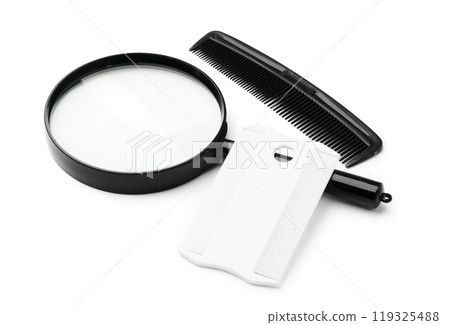 A magnifying glass and lice comb placed side by side on a clean white background 119325488