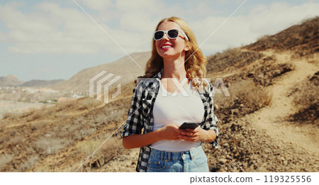 young woman with phone on a hiking trail on top of the mountain, Tenerife, Canary Islands, Spain 119325556