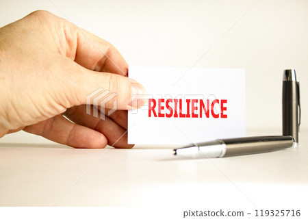 Resilience symbol. Concept word Resilience on beautiful white card. Beautiful wooden background. Businessman hand. Beautiful black pen. Business resilience concept. Copy space. Resilience symbol. Concept word Resilience on beautiful white card. Beautiful wooden background. Businessman hand. Beautiful black pen. Business resilience concept. Copy space. 119325716