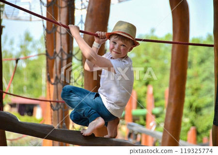 life of children in a modern city - little boy is having fun on the playground near the house 119325774