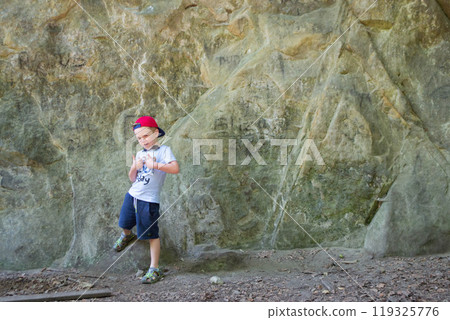 Young boy climbing on a rock, vacation concept. 119325776