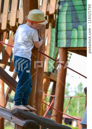 life of children in a modern city - little boy is having fun on the playground near the house life of children in a modern city - little boy is having fun on the playground near the house 119325799
