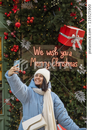 woman walking by city street decorated for christmas woman walking by city street decorated for christmas 119325900