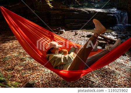 mother with daughter Relaxing in a Hammock in Autumn Forest mother with daughter Relaxing in a Hammock in Autumn Forest 119325902