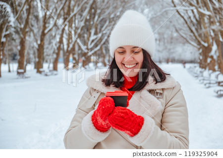 happy woman with coffee cup outdoors at winter cold day 119325904