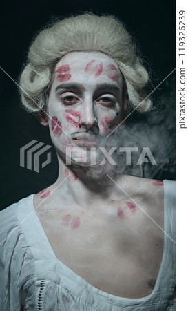 Smoke curls around aristocrat's, adding moody and surreal vibe to this eccentric, lipstick-covered portrait. He remains unfazed and cool. 119326239