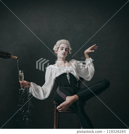 Young man with make-up, posing aristocratically, holding champagne, blends historical charm with modern leisure. Young man with make-up, posing aristocratically, holding champagne, blends historical charm with modern leisure. 119326265