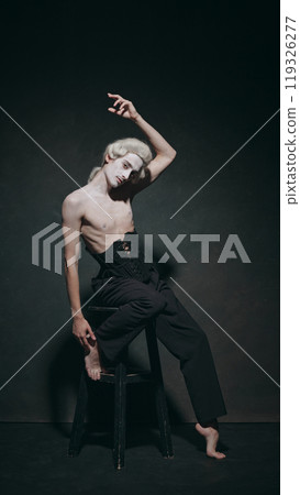Young man sits with dramatic tilt, embodying both sophistication of history and minimalism of contemporary fashion. Young man sits with dramatic tilt, embodying both sophistication of history and minimalism of contemporary fashion. 119326277