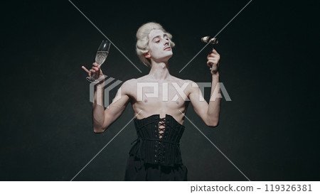 Young man with make-up holds champagne glass, exuding aristocratic vibes with touch of modern surrealism against vintage background. 119326381