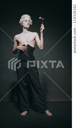 Pale man stands with dramatic posture, holding opera glass, and nod that classic elegance mixed with modern minimalism. Pale man stands with dramatic posture, holding opera glass, and nod that classic elegance mixed with modern minimalism. 119326382