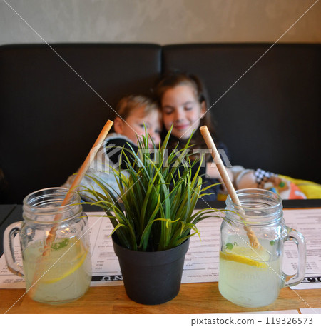The child himself pours lemonade into a glass The child himself pours lemonade into a glass 119326573