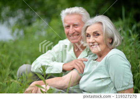 Portrait of senior couple sitting on the grass in the park Portrait of senior couple sitting on the grass in the park 119327270