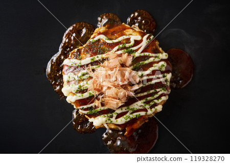 Okonomiyaki baked on an iron plate 119328270