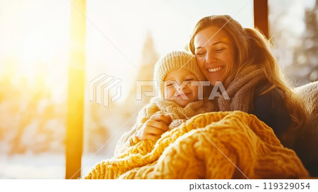 Mother and child enjoying cozy moments together by the window on a snowy day. 119329054
