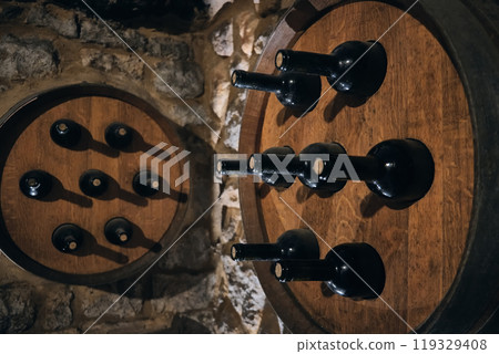Wine bottles sticking out of barrells 119329408