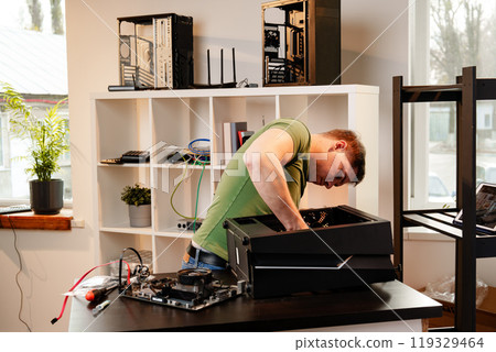 Man assembles a computer system unit at home 119329464