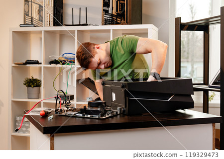 Man assembles a computer system unit at home Man assembles a computer system unit at home 119329473