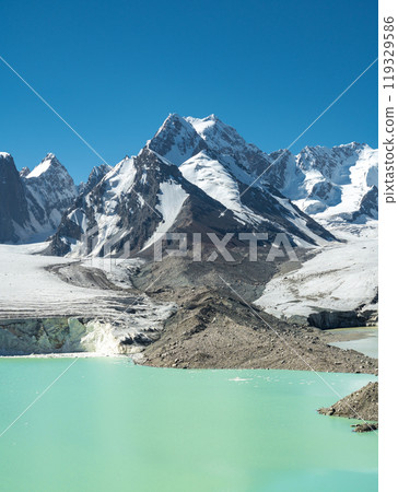 Panorama of the foothills of Mount Kyzylasker, a glacier with a moraine blue lake in the highlands. Ancient arctic large glacier in sunny weather 119329586